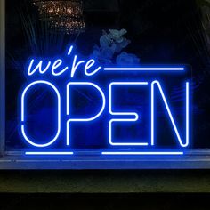 a neon sign that says we're open