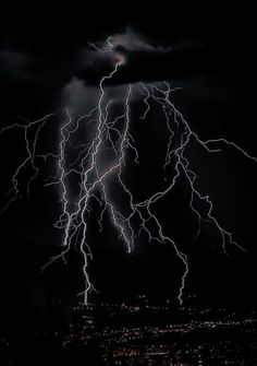 lightning strikes over the city at night