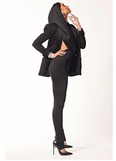 a woman in tights and heels is standing with her hands on her hips while talking on the phone