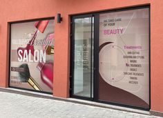 the front window of a beauty salon with advertising on it's windows and doors