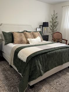 a bed with green and white comforter in a bedroom