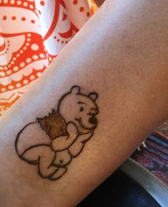 a tattoo on the leg of a person with a bear holding a piece of wood