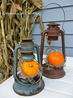 two pumpkins sitting on top of an old rusty lantern next to some corn stalks