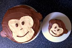 two cupcakes with chocolate frosting and monkeys on them