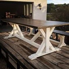 a wooden table sitting on top of a wooden deck next to a garage door,