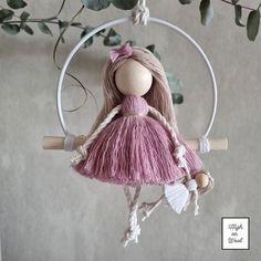 a wooden doll hanging from a hoop on a wall