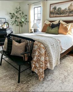 a bed sitting next to a window in a bedroom on top of a white rug