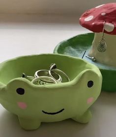 an elephant shaped bowl with rings in it and a mushroom on the other side, sitting on a table