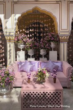 a living room filled with pink couches and vases on top of each other