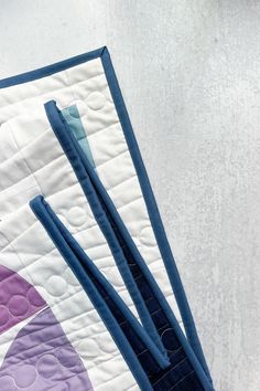 three pieces of blue and purple quilted material on top of each other in front of a white background