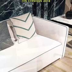 a white couch sitting in front of a marble wall