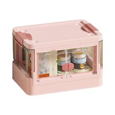 a pink lunch box with some food in it's compartment and the lid open