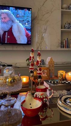 a christmas scene with santa clause on the television screen and other holiday decorations in front of it