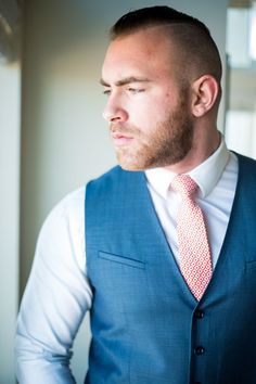 a man wearing a blue vest and red tie