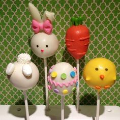 four lollipops in the shape of bunnies and carrots with bows on them