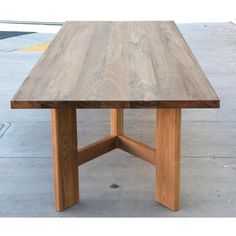 a wooden table sitting on top of a sidewalk