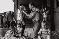 a group of people standing on top of a wooden porch