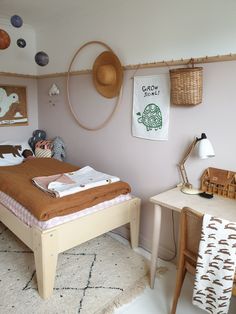 a bed room with a neatly made bed next to a desk and chair in it