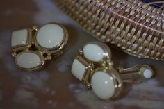 "It is hard not to like this wonderful pair of Vintage Givenchy cream enamel clip on earrings. They are in like-new vintage condition. The cream enamel is so nice it still looks wet. The gold trim is brilliant. These clusters of cabochons are an elegant reminder of styles from the 30's and 40's. They would be stunning paired with tan or black accents to display a \"Spectator\" type look. Nice weight and well made. Photo props not included. NOTE: We are happy to ship to our friends around the glo Elegant Yellow Gold Enamel Clip-on Earrings, Vintage Gold Enamel Clip-on Earrings, Elegant Enamel Clip-on Earrings, White Vintage Clip-on Earrings For Formal Events, Vintage Clip-on Enamel Jewelry, White Enamel Clip-on Jewelry, Jackie O Style, Vintage Givenchy, The Cream