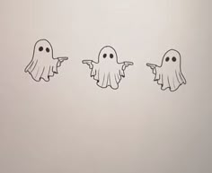 three ghost stickers in the shape of fingers pointing at each other with eyes drawn on them