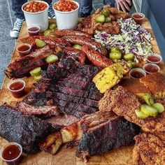 a wooden table topped with lots of different types of meats and other food items