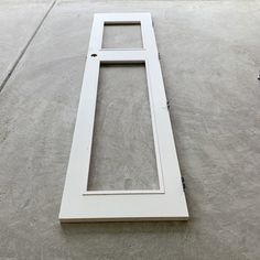 an open window sitting on top of a cement floor next to a white door frame