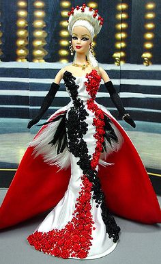 a barbie doll dressed in an evening gown with red and black flowers on the skirt