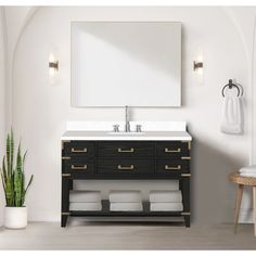 a bathroom vanity with a mirror above it and two towels hanging on the wall next to it