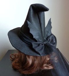 a woman's head wearing a black witches hat