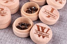 six personalized wooden cufflinks with name and initials on them, all in different shapes and sizes