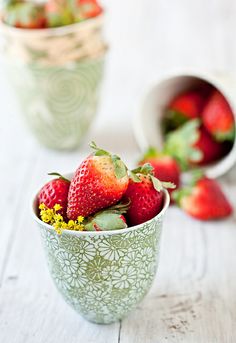 strawberries are sitting in small bowls on the table