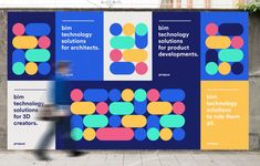 a man walking past a large poster on the side of a building that says ibm technology for architecture