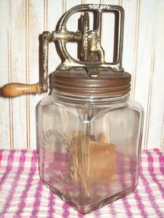 a glass jar with a wooden spoon in it sitting on a checkered table cloth