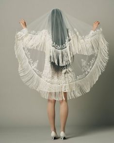 the back of a woman's dress with white fringes