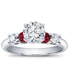 a diamond and ruby engagement ring with three stones on the band, set in 18k white gold