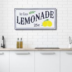 a white brick wall with a lemonade sign hanging on it's side next to a kitchen counter