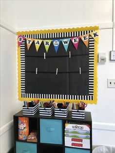 a chalkboard on the wall in a playroom with toy bins and toys