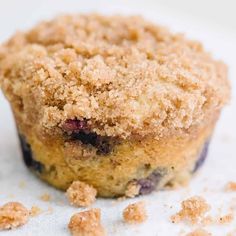 a blueberry muffin with crumbs on top