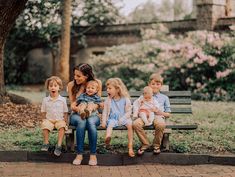 a woman sits on a bench with her five children