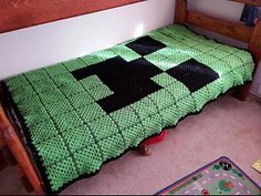 a child's bed with a green and black blanket