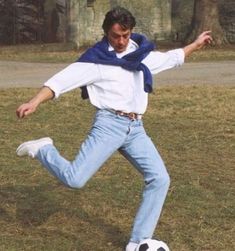 a man kicking a soccer ball on top of a field