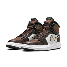 Introducing the Nike Womens Air Jordan 1 Acclimate Chocolate! This sneaker-boot hybrid is perfect for those cold winter days. The upper is made of brown and white leather, with rolled edges and a rubberized heel overlay. The lacing system includes speed hooks and D-ring eyelets. The quilted textile collar and tongue feature a faux fur lining. Above the white rubber midsole is a matching white rubber wrap. The brown cored-out rubber outsole provides grip and durability. Nike Jordan Brown, Air Jordan 1 Acclimate, Womens Air Jordan 1, Womens Air Jordan, Wmns Air Jordan 1, Womens Air Jordans, Outfit Plan, Nike Womens, Winter Days