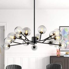 a modern chandelier hangs over a dining room table