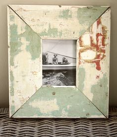 an old photo frame sitting on top of a wicker basket next to a wall