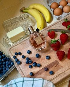 some strawberries and blueberries are on a cutting board