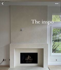 an empty room with a fire place in the middle and a window above it that reads the inspo