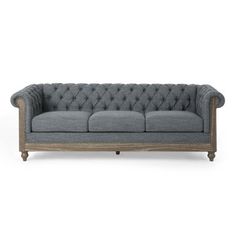 a grey couch with wooden legs and buttons on the back, against a white background