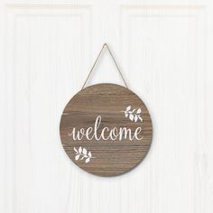 a wooden sign hanging on the side of a door that says,'welcome '