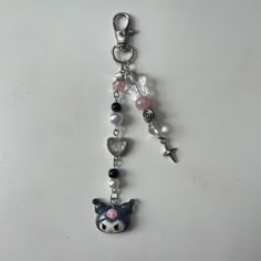 a key chain with an animal charm hanging from it's side on a white surface