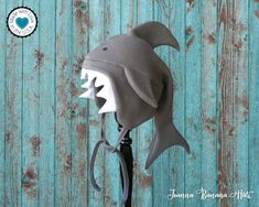 a stuffed shark head on top of a black umbrella stand against a blue wooden wall